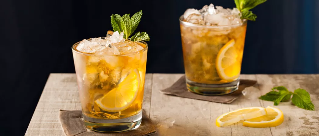 Two glasses of Whisky Smash garnished with crushed ice and mint leaves