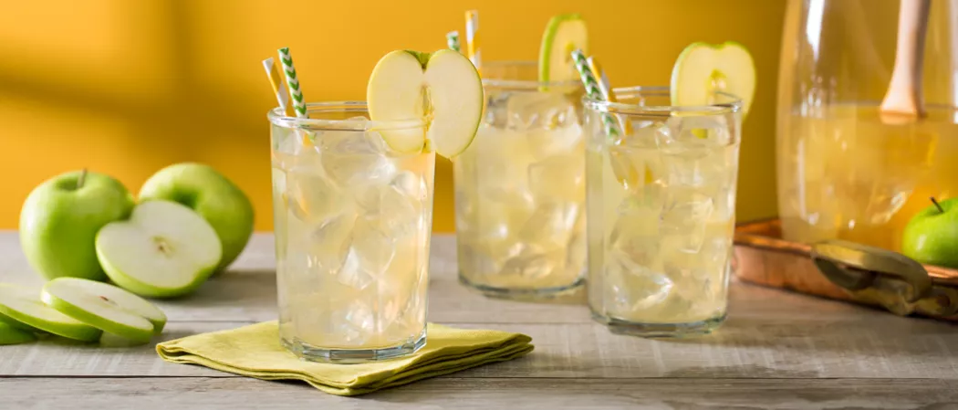 Three glasses of Crisp Apple Ade garnished with green apple slice