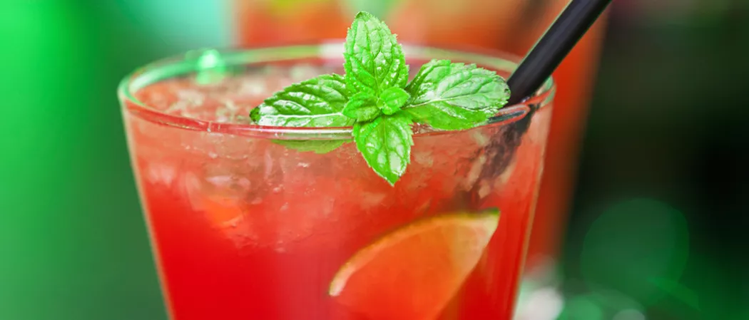 Glass of Berry Burst with straws and lemon slices garnished with mint leaves