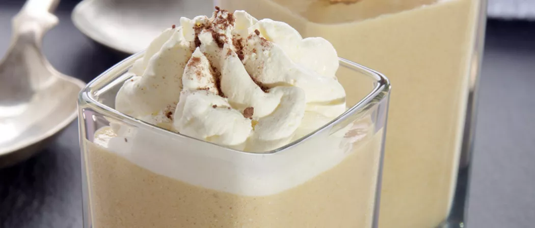 Glass of Buttery Nipple garnished with whipped cream
