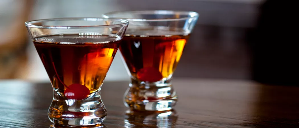 Two glasses of Classic Manhattan, each garnished with a cherry
