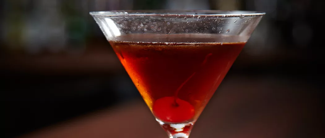 A glass of Classic Manhattan garnished with a cherry