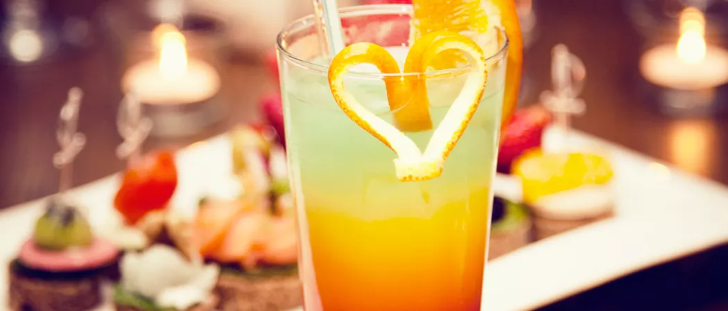 Glass of Hurricane garnished with heart made of orange peel