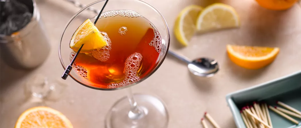 Glass of Samuels garnished with a orange zest.