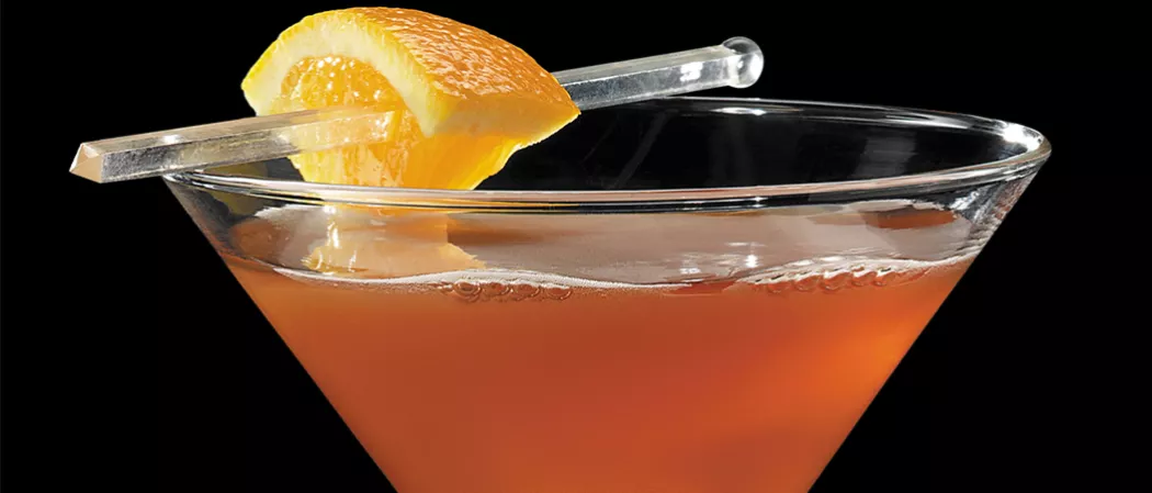 Glass of Samuels garnished with a orange zest.