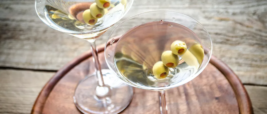 Two glasses of Dirty Martini garnished with olives
