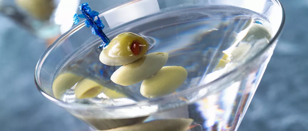 Glass of Dirty Martini garnished with olives