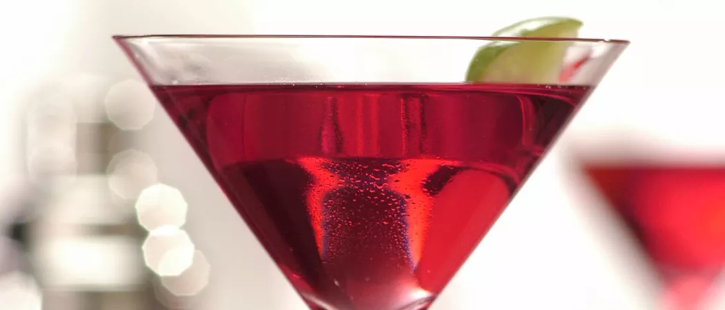 A Glass of Classic Cosmo garnished with lime slice