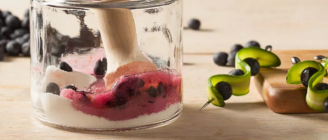 muddling blueberries in jar