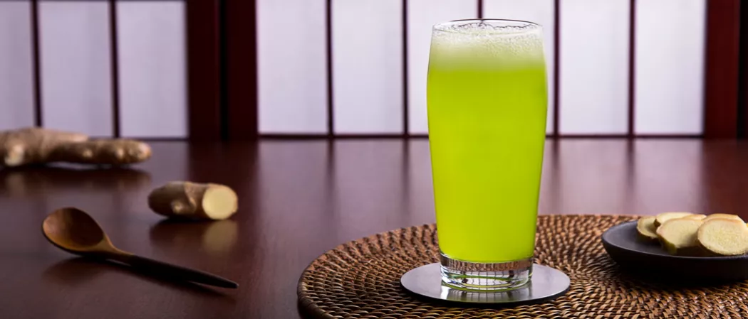 a glass of Midori and ginger beer liquid on a table
