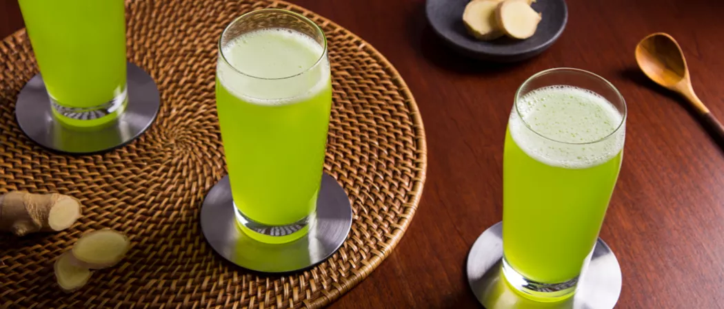 Three a glass of green midori and ginger beer on a table